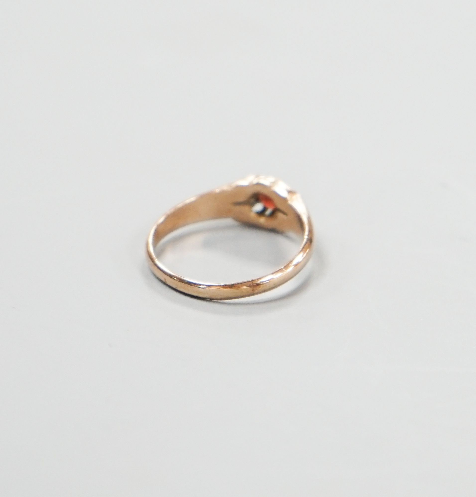 An Edwardian 9ct gold and claw set garnet ring, size N, gross 2.2 grams.